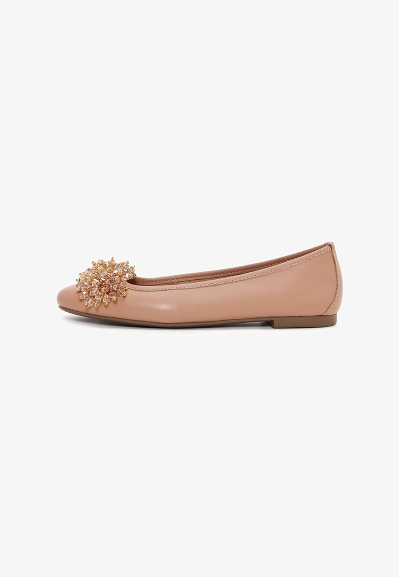 Nude leather ballet flats featuring a rounded toe and a decorative, sparkling floral embellishment on the vamp. Flat sole.
