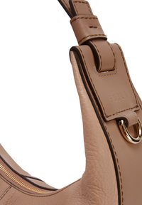 Borsa a tracolla in pelle color cannella con una texture liscia. Presenta un accentuazione in anello dorato e una chiusura a zip. Il marchio è visibile sulla tracolla.