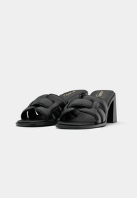 Schwarze Absatzsandalen mit einem breiten, überkreuzten Riemen-Design, aus glattem Leder, mit Blockabsatz und offener Zehenpartie.