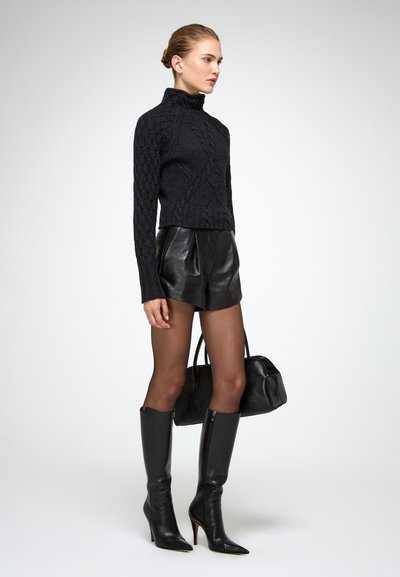 Musthave mustarvest, kudumissoonik, nahast kõrge vöökoht, läbipaistvad sukkpüksid ja mustad kõrge kontsaga saapad, must käsipagas.