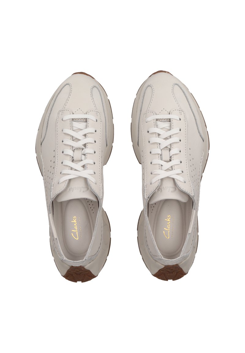 Baskets en cuir blanc avec des détails perforés et des accents gris. Présentent des lacets blancs et une semelle extérieure en caoutchouc brun clair.