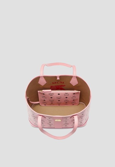 Borsa tote in pelle rosa MCM con doppi manici, tasca interna con zip e fodera beige con loghi MCM rossi e neri.