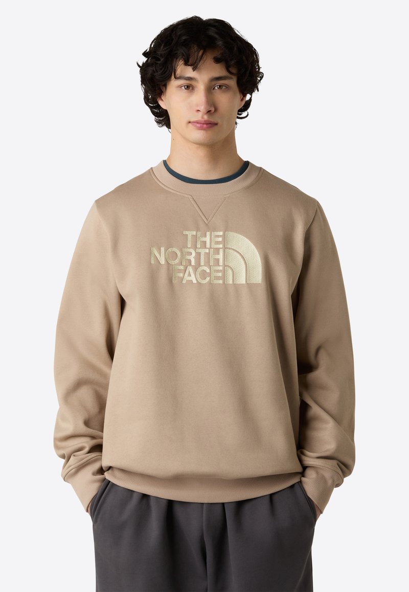 Beige sweatshirt med rund hals, præget med stort logo. Blødt stof, afslappet pasform, ribbede manschetter og talje.