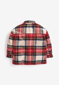 Chemise à carreaux rouges en tissu doux, présentant un motif à carreaux classique avec des accents noirs et bleus, des poignets rabattables et un détail de gousset au dos.