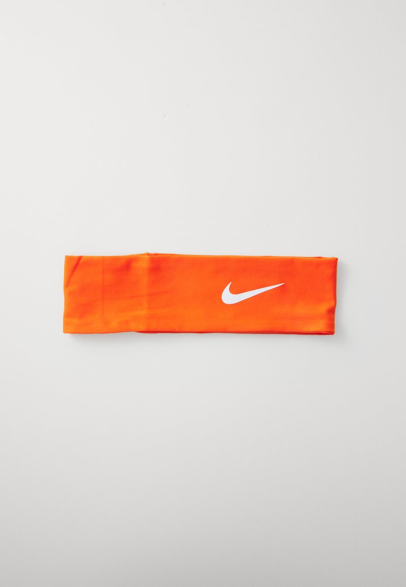 Nike peapael, oranž kangas, sile tekstuur, kitsas disain, millel on ühe külje peal valge Nike logo.
