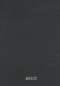 Černý texturovaný kožený povrch se stříbrným logem "estro" v pravém dolním rohu, který ukazuje hladký, ale jemně zrnitý povrch.