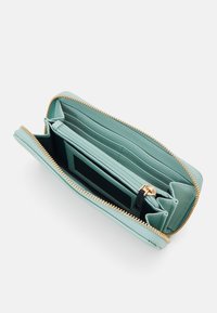 Mint green leather wallet with a gold zipper, featuring multiple card slots and a central compartment. Inside has a textured lining.