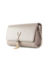 Borsa a mano in pelle di colore taupe con una finitura testurizzata. Presenta una tracolla in catena dorata e un accento con nappina vicino a un logo in evidenza.