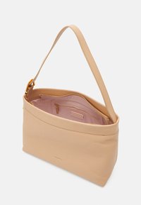Sac à épaule en cuir tan avec une texture lisse, des éléments en or et un intérieur rose. Il dispose d'une poche zippée et d'un design ouvert.