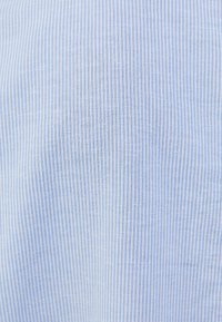 Světle modrý látkový materiál s tenkými vertikálními bílými pruhy, texturovaná vazba a hladký povrch, vhodný pro oděvy nebo domácí textilie.