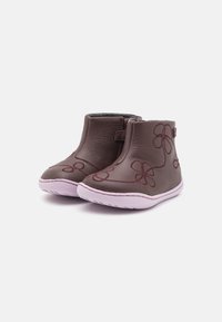 Botas de cuero marrón hasta el tobillo con una suela de goma morada, con un diseño de bordado floral y un zipper lateral para el cierre.