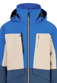 Niebieska i beżowa sportowa kurtka z wysokim kołnierzem, zamkiem błyskawicznym z przodu, dwiema kieszeniami na zamek oraz wzorem w blokach kolorowych.
