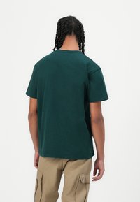 Green cotton T-shirt with a classic crew neckline, short sleeves, and straight cut, viewed from the back.