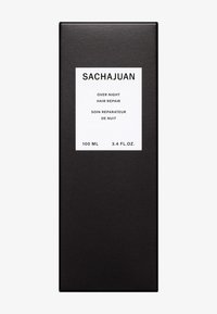 Svart rektangulär förpackning för Sachajuan Overnight Hair Repair, med en vit etikett som visar produktens namn och volym (100 ml, 3,4 fl. oz.).