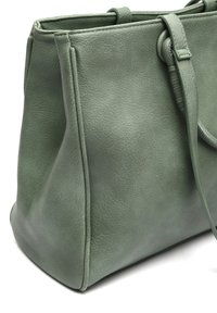 Vihreä nahkainen kangaskassi, jossa on sileä pinta, jämäkkä muoto ja kaksoiskäsittelyt. Ominaisuuksina siisti ommeltys ja minimalistiset muotoiluelementit.