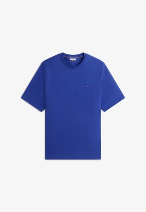 Blaues T-Shirt mit kurzen Ärmeln und Rundhalsausschnitt, mit kleinem rot-weiß-blauem Flaggenlogo auf der linken Brust, vor weißem Hintergrund dargestellt.