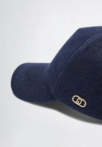 Navy blue cap with a textured fabric, curved brim, and a gold accent logo on the side. Features slight sheen and structured shape.