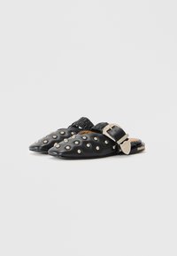 Black leather mules featuring rounded toes, silver stud accents, and a textured black buckle. Smooth finish with a low heel.
