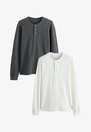 Zwei langärmelige Henley-Shirts, eines in Dunkelgrau und eines in Weiß, jeweils mit einer Dreiknopfleiste und gerippten Bündchen.