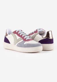 Sneaker bianchi e viola con dettagli in suede, pelle e accenti metallici. Presentano una punta perforata, lacci in contrasto e suola in gomma.