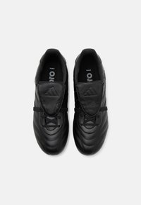 Baskets noires avec une tige en cuir texturé, un design matelassé, un système de laçage et une languette rembourrée arborant le logo Adidas.