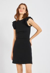 Schwarzes, geripptes Kleid mit fransigen kurzen Ärmeln, tailliertem Oberteil und leicht ausgestelltem Rock, der eine glatte Textur und minimalistisches Design betont.