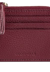 Portafoglio in pelle bordeaux con finitura testurizzata. Dotato di chiusura con zip e numerosi slot per carte per una migliore organizzazione. Marchio impresso.