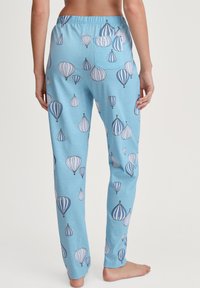 Lichtblauwe pyjamabroek met meerkleurige luchtballonprints, voorzien van een elastische tailleband en een achterzak. Zacht, glad materiaal.