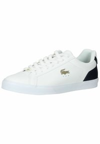 Adidași din piele albă cu accent negru la călcâi, talpă plată din cauciuc și detaliu cu logo auriu pe lateral. Dispun de vârf rotund și design cu șireturi.
