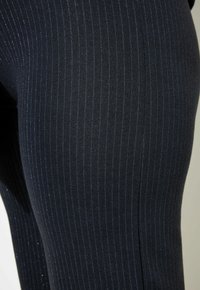 Marine ribbed leggings met een gestructureerde afwerking, voorzien van subtiele blauwe streepjes, een elastische tailleband en een gladde, aansluitende pasvorm.
