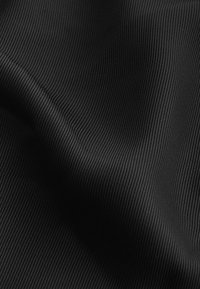 Textureret sort stof med vertikale ribbede linjer, blød overflade og glat fald, velegnet til forskellige tekstilapplikationer.