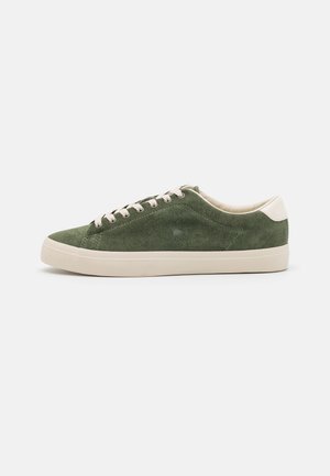 Grüne Wildledersneaker mit cremefarbenen Akzenten, flachen Schnürsenkeln und Gummisohlen. Schlankes Design, strukturiertes Material und minimales Branding.