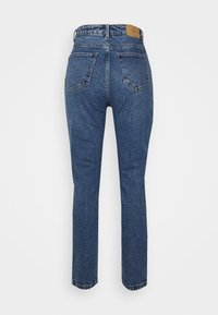 Jeans de ganga azul de cintura alta com perna reta, apresentando cinco bolsos, um rótulo de couro na parte de trás e um acabamento ligeiramente desbotado.