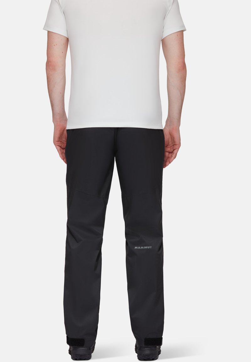 Pantalons outdoor noirs en tissu durable, présentant un design élégant, une taille élastique et le logo 'Mammut' sur la jambe inférieure.