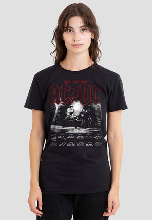 Black cotton T-shirt featuring AC/DC logo in red, vintage concert graphic, and "50 Years" text. Short sleeves and crew neckline.