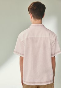 Short-sleeve, light pink shirt made from linen, featuring detailed embroidery along the collar and sleeve hems. Back view displayed.