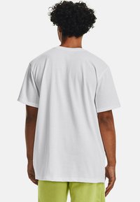 Hvid bomulds T-shirt med løs pasform, korte ærmer og rund hals, med et enkelt design og glat tekstur på bagsiden.