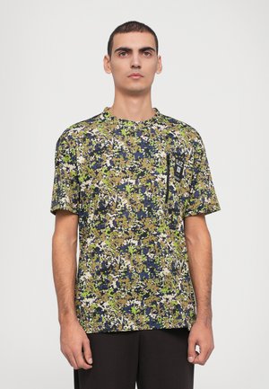 T-skjorte med kort erm i camouflage-mønster i grønn, beige og marineblå; har en lomme på venstre bryst med en logo. Mykt stoff, avslappet passform.