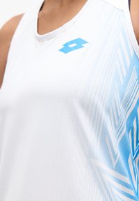 Λευκό αμάνικο αθλητικό τοπ με μπλε γεωμετρικά σχέδια στο πλάι και ένα μικρό μπλε λογότυπο στο στήθος.