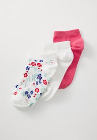 Tre paia di calzini alla caviglia: un paio bianco con un motivo floreale in rosso e blu, e due di colore solido, uno rosa e uno bianco.