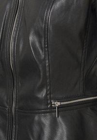 Section d'une veste en cuir noire montrant une fermeture éclair centrale verticale et une poche zippée horizontale avec des fermetures éclair en métal argenté et des coutures cousues.
