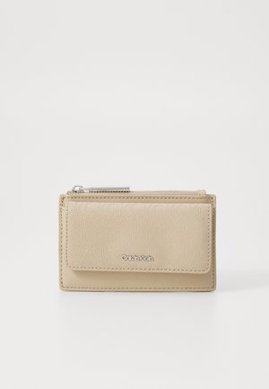 Bežna torbica Calvin Klein z teksturirano površino, z zadrgo za zapiranje in sprednjim poklopcem, ki vsebuje vtisnjen vzorec ter podrobnosti logotipa.