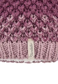 Knitted purple and pink wool hat with a textured pattern and a beige fabric tag labeled "Sterntaler" at the bottom edge.