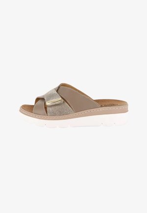 Sandalo slip-on beige in pelle e suede con suola bianca spessa e dettaglio dorato sul cinturino incrociato.