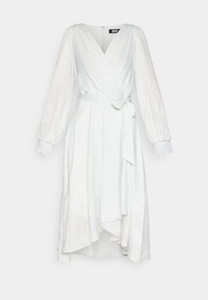 Biele oblečenie s dlhými nadýchanými rukávmi, viazaním v páse a rozšíreným lemom. Hladká, mierne lesklá tkanina s jemnou textúrou.