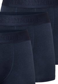 Ciemnoniebieskie bawełniane bokserki z miękkim, teksturowanym paskiem w talii z wytłoczonym logo. Trzy pary pokazane w ułożeniu jedno na drugim.