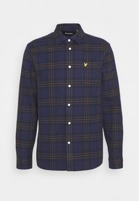 Chemise à carreaux bleu marine avec des boutons blancs, dotée d'un col boutonné et d'un petit logo jaune sur la poche poitrine.