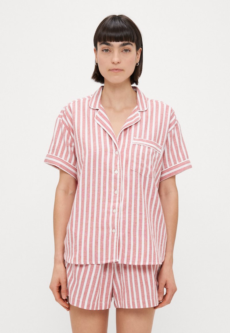 Ensemble de pyjama à manches courtes rayées en rose et blanc, avec des boutons, une poche poitrine et une coupe ample. Fabriqué en tissu doux et léger.