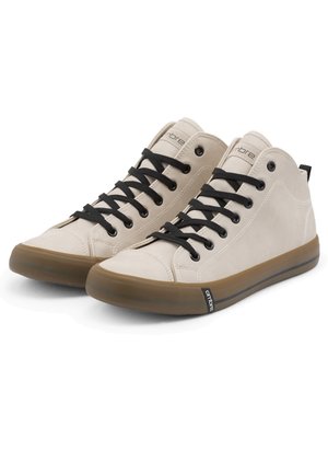 Beige høje sneakers med sorte snørebånd og brune gummisåler side om side på en hvid baggrund.