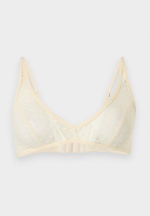 Bralette en dentelle beige avec bretelles réglables et fermeture à agrafes, avec un motif floral subtil et une doublure en tissu doux.